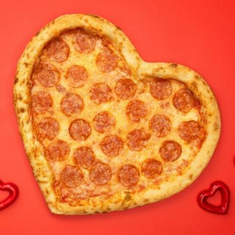 südamekujuline pizza pepperoni sõbrapäevaks punase paberi taustal
